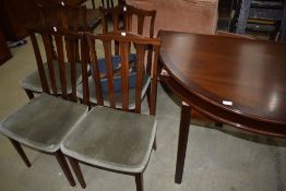 A modern mahogany circular dining table, extendable with four rail back dining chairs