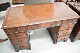 An early 20th century pedestal desk having veneer fronts with brown skiver leather top