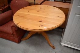 A modern pine pedestal dining table
