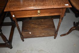 An early 20th Century oak side table having twist frame