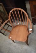 A vintage low seat carver chair having spindle back, probably Ercol, stamped 2065