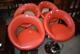 A set of four vintage style red vinyl and chrome bar stools