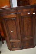 A 19th Century mahogany corner cupboard having panelled doors