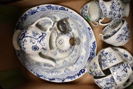 A mixture of blue and white ceramics, inlcluding platters, tea pot and cups and saucers.