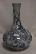 An oriental possibly Vietnamese bottle form squat vase decorated with typical blue and white