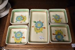 An Art Deco Clarice Cliff Wilkinson set of five hand decorated dishes with oak tray.