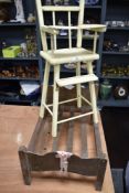 A vintage wooden dolls bed and a high chair.