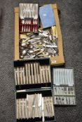 A box full of vintage and antique table ware, including MOP and bone handled knives, boxed cake