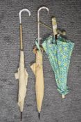 Two 1940s/50s umbrellas having celluloid handles, also included is a vintage parasol having been