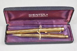 A Sheaffer Targa gold plated fountain pen and pencil set with reeded design in original box