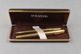 A boxed Sheaffer button fill fountain pen and propelling pencil in gold fill with white spot