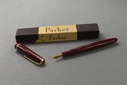 A Parker Junior Duofold fountain pen in red with decorative band to cap having Parker 10 nib in