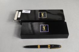 A boxed Yves Saint Laurent converter fountain pen in black with gold trim in original package