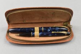 A Conway Stewart 15 lever fill fountain pen and propelling pencil set in blue marble in leather