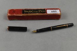 A Mabie Todd Swan SF1 lever fill fountain pen in black with clipless cap having woodgrain band and