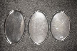 Three vintage stainless steel platters.