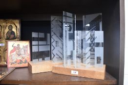 Two pieces of abstract statement art glass in wooden mounts.