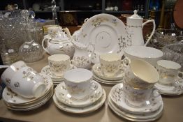 An antique partial tea service having white ground with gilt floral design, tea and coffee pots,