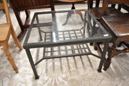 A modern metal and glass square coffee table