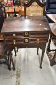 A period oak desk on cabriole legs having slope top and frieze drawer