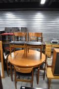 A vintage teak G plan or similar circular dining table and set of six similar dining chairs