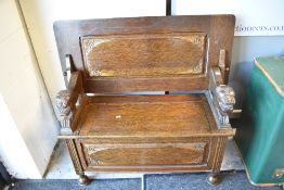 A traditional oak monks bench having lion handles
