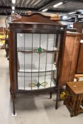 An early 20th century mahogany display cabinet having leaded glass door