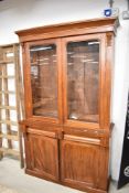 A Victorian glazed mahogany bookcase over cupboard, 203CM. X. 119CM.