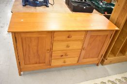 A modern part pine sideboard, with four central drawers flanked by cupboards