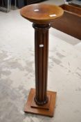 A traditional mahogany torchere or plant stand in a period style