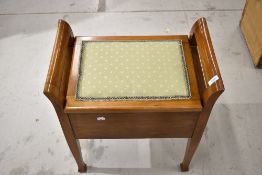 An early 20th Century stained frame piano stool with under seat storage