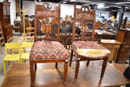 A pair of Victorian mahogany high back dining chairs having upholstered seats and shoulder rails