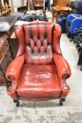 A traditional red leather wingback chair