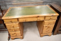 A modern Ducal pine twin pedestal desk, of traditional design with green tool leather skiver.
