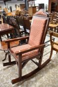A large 20th century mahogany upholstered rocking chair, having studded construction. Seat height 64