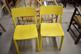 A pair of yellow plastic chairs
