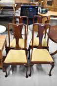A set of four early 20th Century mahogany dining chairs in the Queen Anne style having vase backs