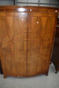 An early 20th mahogany and walnut bow fronted wardobe