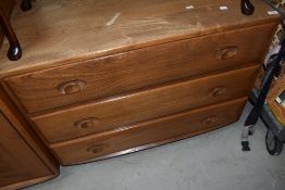 An Ercol mid or light stain low chest of three drawers