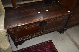 A period oak coffer of simplistic design , with carvings to front panel including love token style