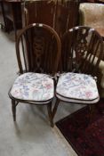 A pair of traditional dark stained wheelback kitchen chairs