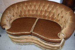 A vintage settee of curved button back form (please note this does not comply with current fire