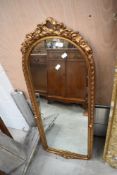 A portrait wall mirror having gilt swag decoration to frame