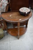 An early to mid 20th Century half moon hall table and a traditional woolwork foot stool