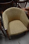 A traditional upholstered tub chair with turned frame