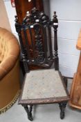 A 19th Century oak hall chair having carved rail back and woolwork seat