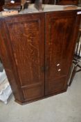 A 19th Century oak corner cupboard having panelled doors