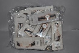 A bag full of ladies fashion watches new in packaging.