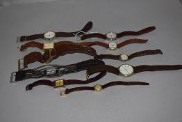 10 wrist watches all having brown straps.