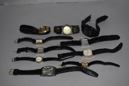 A selection of wrist watches all having black straps